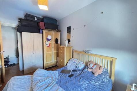 A cozy bedroom featuring a bed with plush toys,...