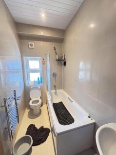 Bright and clean bathroom featuring a bathtub, ...