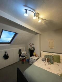 A cozy bedroom with a sloped ceiling featuring ...