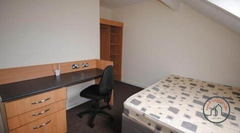 A tidy single bedroom featuring a bed, study de...