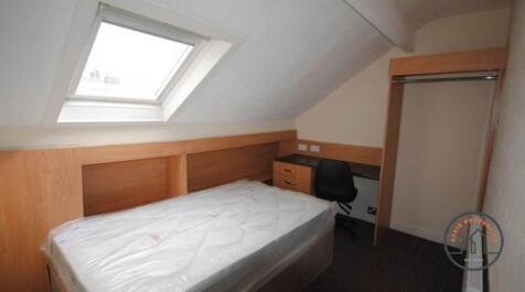 A compact bedroom with a single bed, a wardrobe...