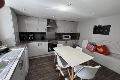 A bright and modern kitchen featuring white cab...