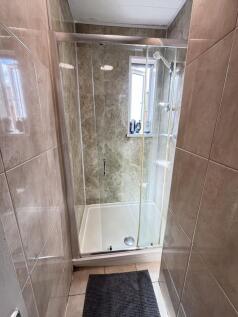A clean and modern bathroom with a spacious sho...