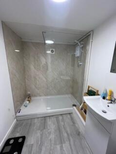 A clean and modern bathroom with a fitted showe...