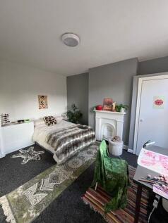 A cozy single bedroom featuring a comfortable b...