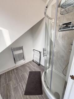 A modern bathroom featuring a curved glass show...