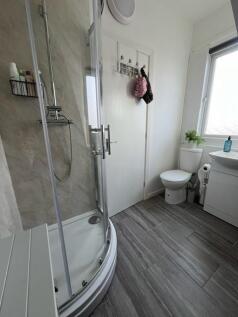 A clean and bright bathroom featuring a shower ...