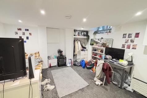 A modest living room with a TV, some scattered ...