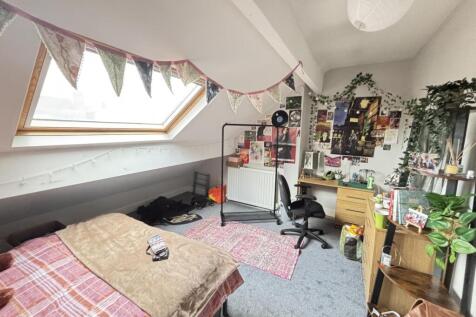 A cozy bedroom featuring a comfortable bed with...