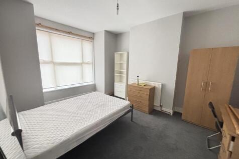 A tidy single bedroom featuring a single bed, a...