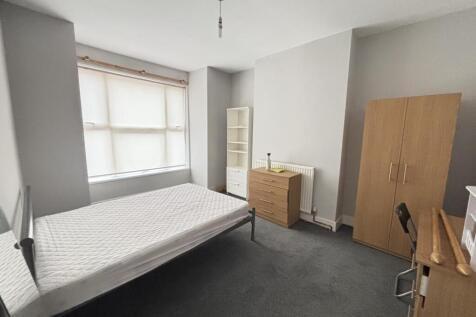 A cozy student bedroom featuring a comfortable ...