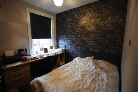 A spacious master bedroom featuring a comfortab...