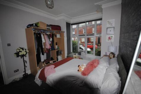 A bright and inviting bedroom featuring a comfo...