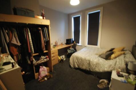 A cozy single bedroom featuring a bed, ample na...