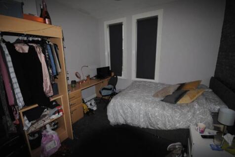 A cozy bedroom featuring a large bed with pillo...