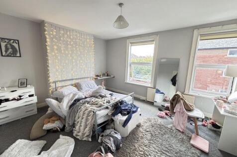 A cozy bedroom with two windows providing natur...