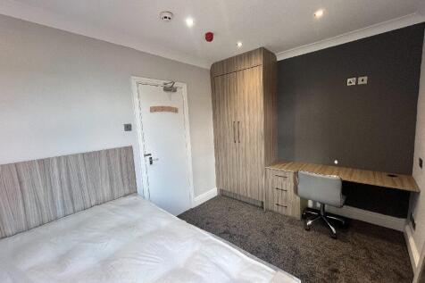 A neatly maintained bedroom featuring a bed, a ...