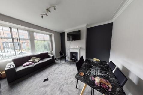 A spacious, well-lit living room with large win...