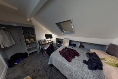 A well-lit bedroom with a comfortable bed, some...