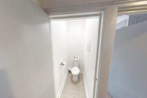 A clean and modern bathroom with a toilet, feat...