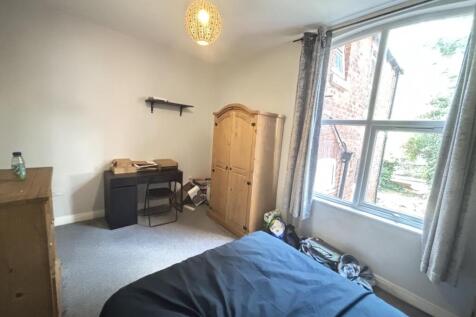 A cozy bedroom with a single bed, a wooden ward...
