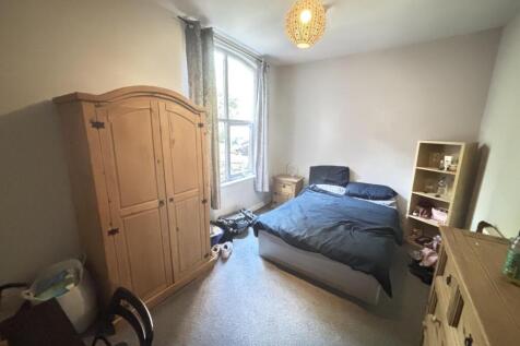 A cozy single bedroom featuring a double bed, a...