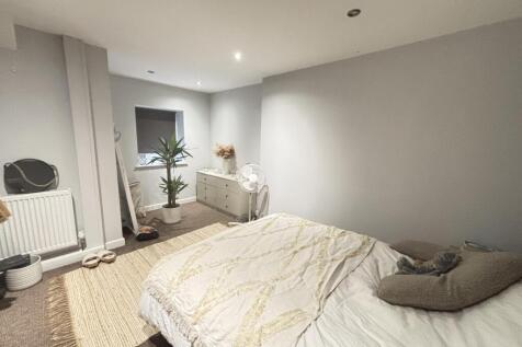 A bright and cozy bedroom featuring a comfortab...