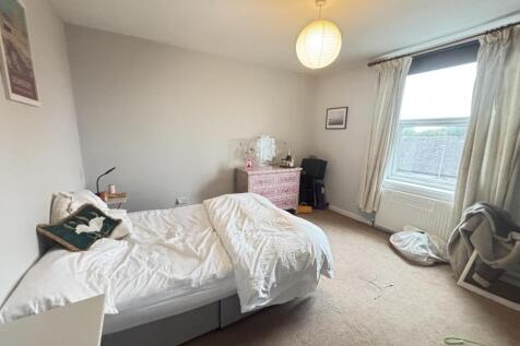 A spacious and bright master bedroom featuring ...