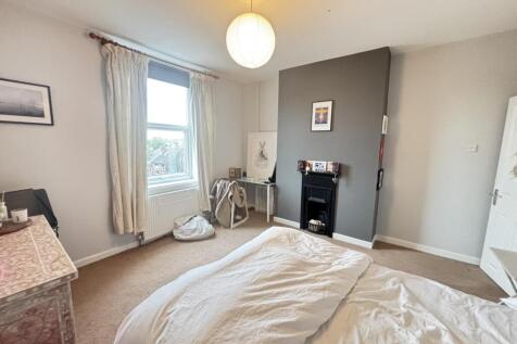 A well-lit, inviting bedroom with a comfortable...