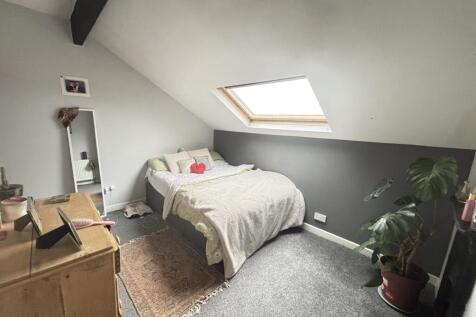 A cozy single bedroom illuminated by natural li...