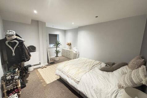 A spacious and well-lit master bedroom featurin...