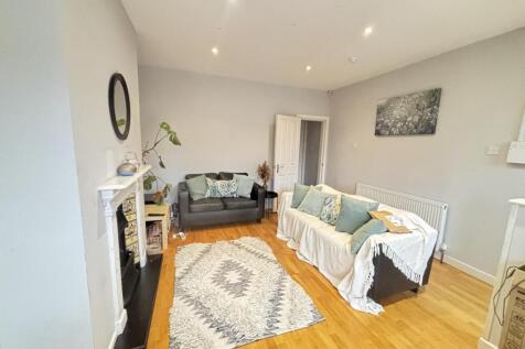 A bright and spacious living room featuring com...