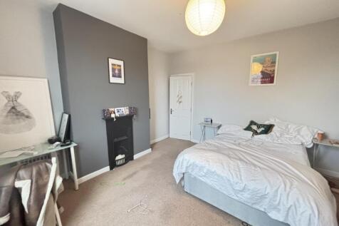 A bright and tidy bedroom featuring a comfortab...