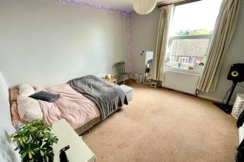 A bright and inviting bedroom featuring a spaci...