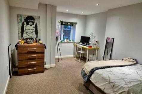 A cozy bedroom with a single bed, ample natural...