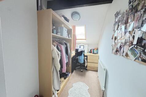 A bright and well-organized bedroom featuring a...