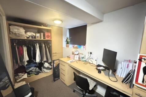 A well-organized bedroom featuring a desk with ...