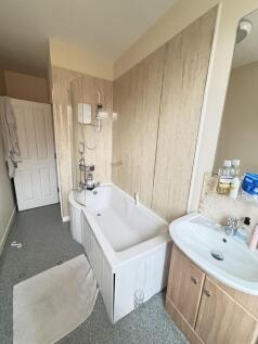 A modern bathroom featuring a bathtub with show...