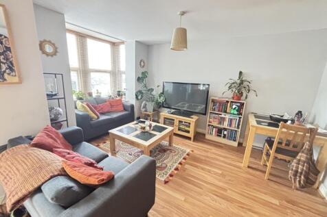 A bright and spacious living room featuring com...