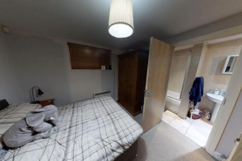 A well-lit, tidy bedroom with a large double be...