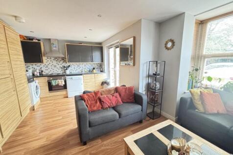 A bright and welcoming living room with ample n...