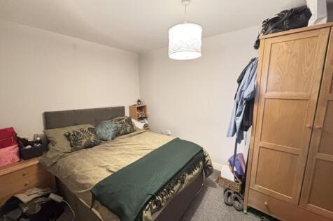 A cozy bedroom featuring a double bed with a he...