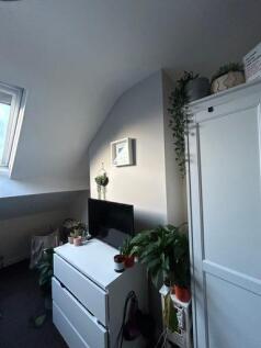 A bright, tidy bedroom with a window providing ...