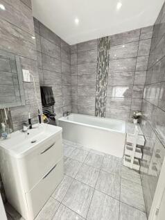 A modern and clean bathroom with a spacious tub...