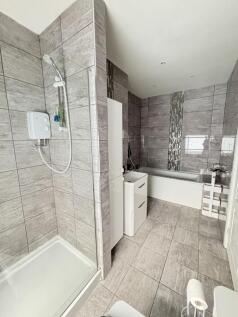 Modern and clean bathroom featuring a shower, b...