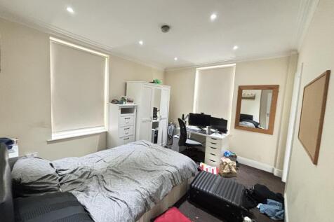 A bright and spacious living room featuring lar...