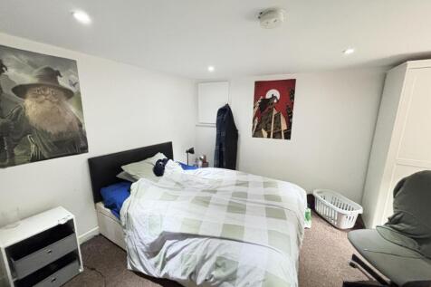 A bright and tidy bedroom with a large bed, mod...