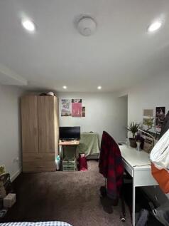 A well-lit living room featuring a comfortable ...