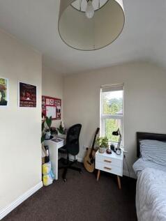 A bright and tidy bedroom featuring a comfortab...