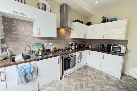 Bright and clean kitchen with ample white cabin...